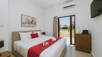A hotel room with a bed, a painting, a desk, and a view of a pool.