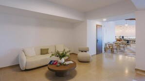 Un salon moderne avec un canapé, une table basse et un coin repas.