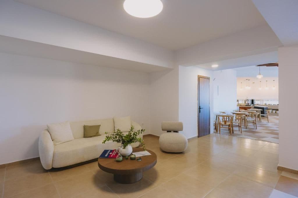 Ein modernes Wohnzimmer mit Sofa, Couchtisch und Essbereich.