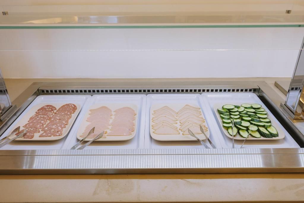 A buffet with various food items including sliced meats and vegetables.