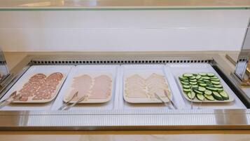 A buffet with various food items including sliced meats and vegetables.