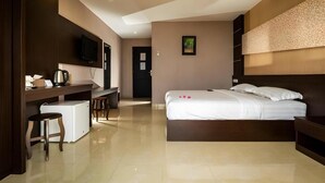 A hotel room with a bed, a desk, a television, and a small kitchenette. - 21 Karimun (Karimun)