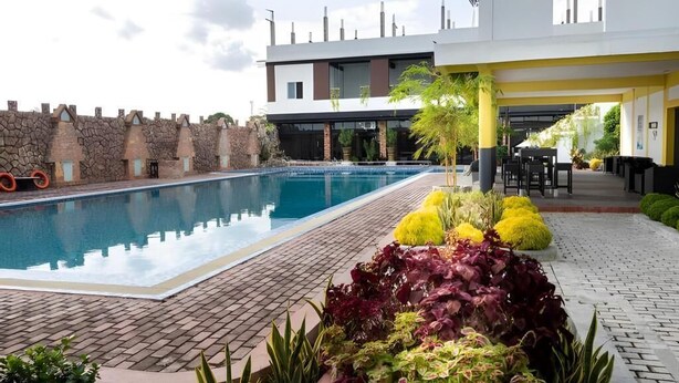 A swimming pool with a brick pathway, surrounded by a stone wall and modern buildings. - 21 Karimun (Karimun)