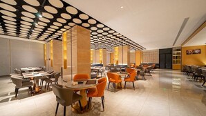 Ein modernes Restaurant mit einem einzigartigen Deckengestalt, verschiedenen Essbereichen und zeitgenössischen Möbeln.