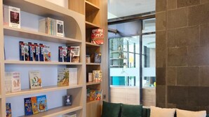 A library with bookshelves and a green sofa. - Laska Hotel and Resort Ciletuh (Girimukti)