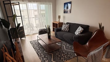 A living room with a sofa, coffee table, and a patterned rug.