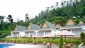 A resort with multiple bungalow-style buildings, a swimming pool, and outdoor seating areas. - Gulala Azana Hotel and Resort Guci Tegal (Songgom)