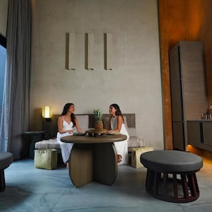 Un intérieur moderne avec une table ronde, deux canapés et un grand meuble.