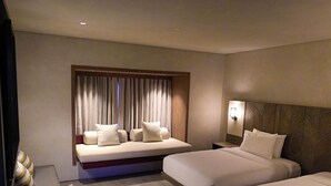 A hotel room with a bed, a sofa bed, a nightstand, and a window with curtains. - Amorita Resort & Spa (Puerto Princesa)