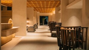 A corridor with a wooden ceiling, chairs, and a potted plant. - Amorita Resort & Spa (Puerto Princesa)
