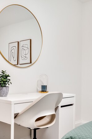 A minimalist room with a white desk, a large round mirror, and two abstract art pieces on the wall. - Executive Suite 3BR - Close to Downtown Ottawa (Ottawa)