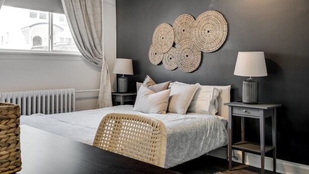 Une chambre à coucher moderne, avec un lit, des tables de chevet et une grande décoration murale.