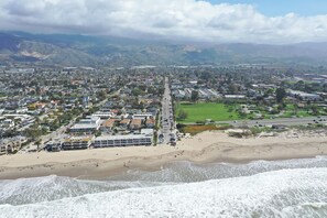 A coastal town with a beach, residential areas, and a long road running through the center.