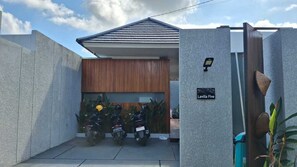 A gated entrance with a sign reading 'Lavilla Five,' a wooden wall, and parked motorcycles. - LaVilla Duo Ubud - 2 Private Pool Villas (Gianyar)