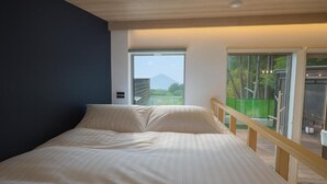 A bedroom with a bed, a view of a balcony, and a door leading outside. - Well Resort Fuji Annex (Gotemba)