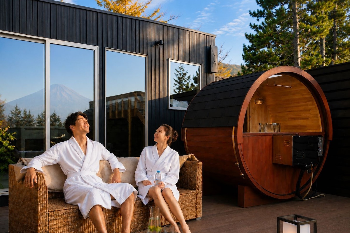 Um casal relaxando em um sofá de vime em frente a um edifício moderno com janelas amplas e sauna.