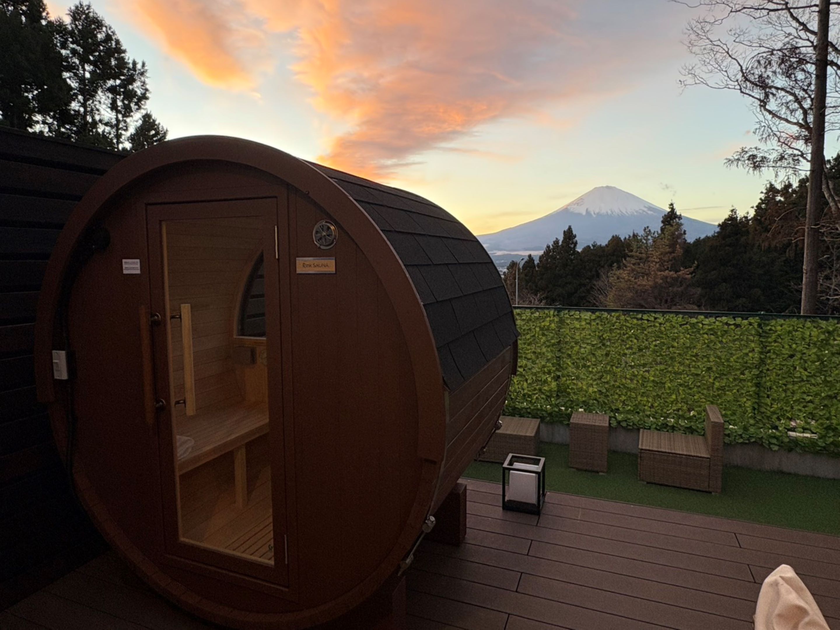 Eine Sauna mit Holzfassade, einer Tür und einem kleinen Schild.