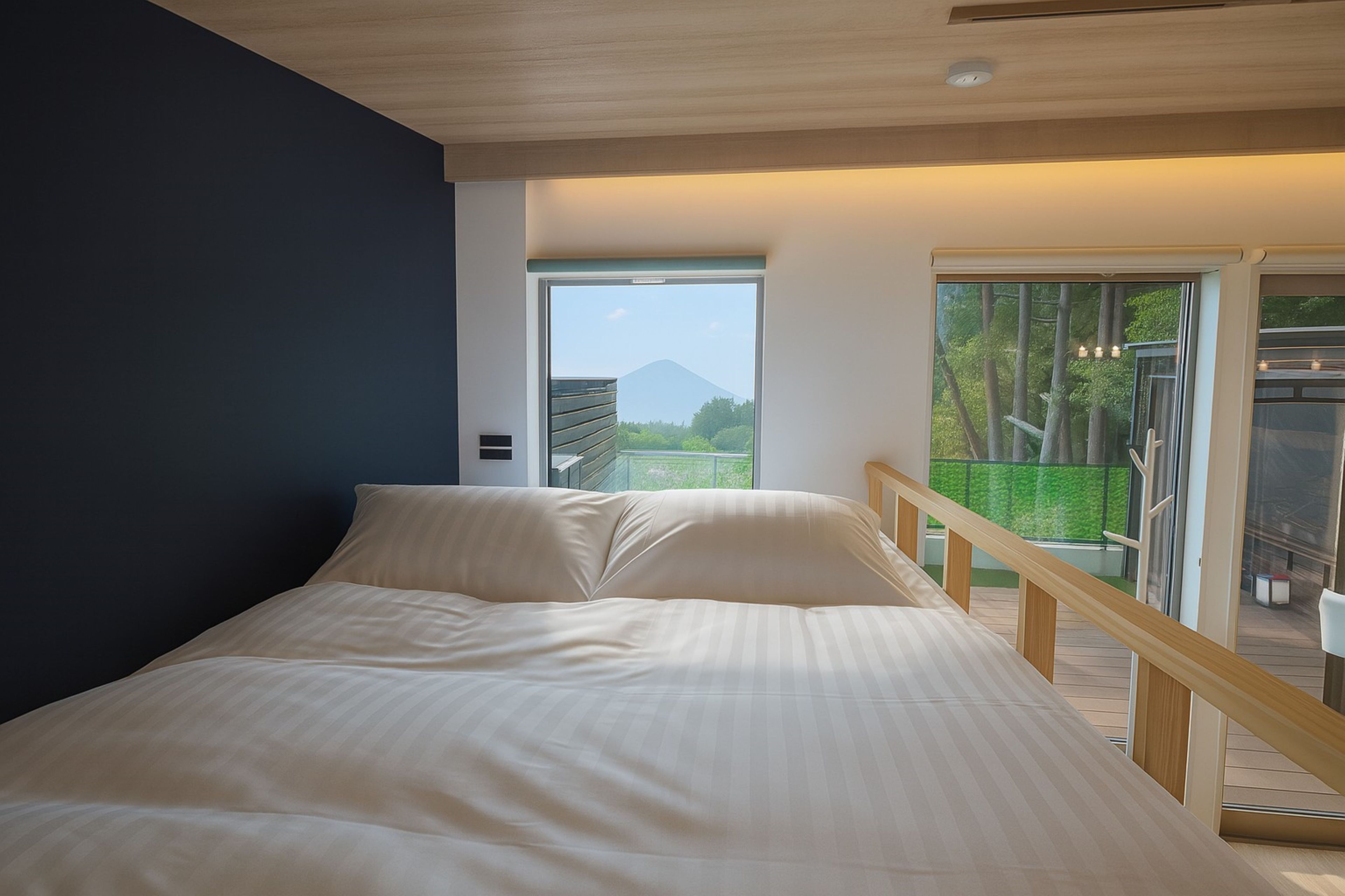 A bedroom with a bed, a view of a mountain, and a balcony with a railing.