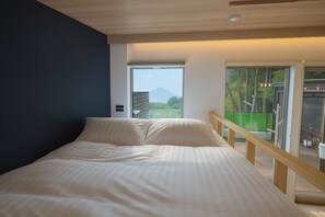 Un dormitorio con cama, vistas a la montaña y un balcón con barandilla.