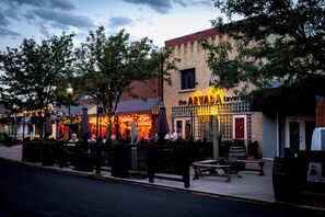 A street scene with a building labeled 'the ARVADA tavern' featuring outdoor seating and a brick facade. - One Block From Olde Town! Hot Tub, Fire Pit, Putting Green, Arcade & Game Room (Arvada)