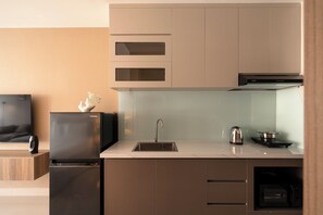 A modern kitchen with a built-in refrigerator, a sink, and a stove. - Maison De Gu Co Giang Apartment (Ho Chi Minh City)