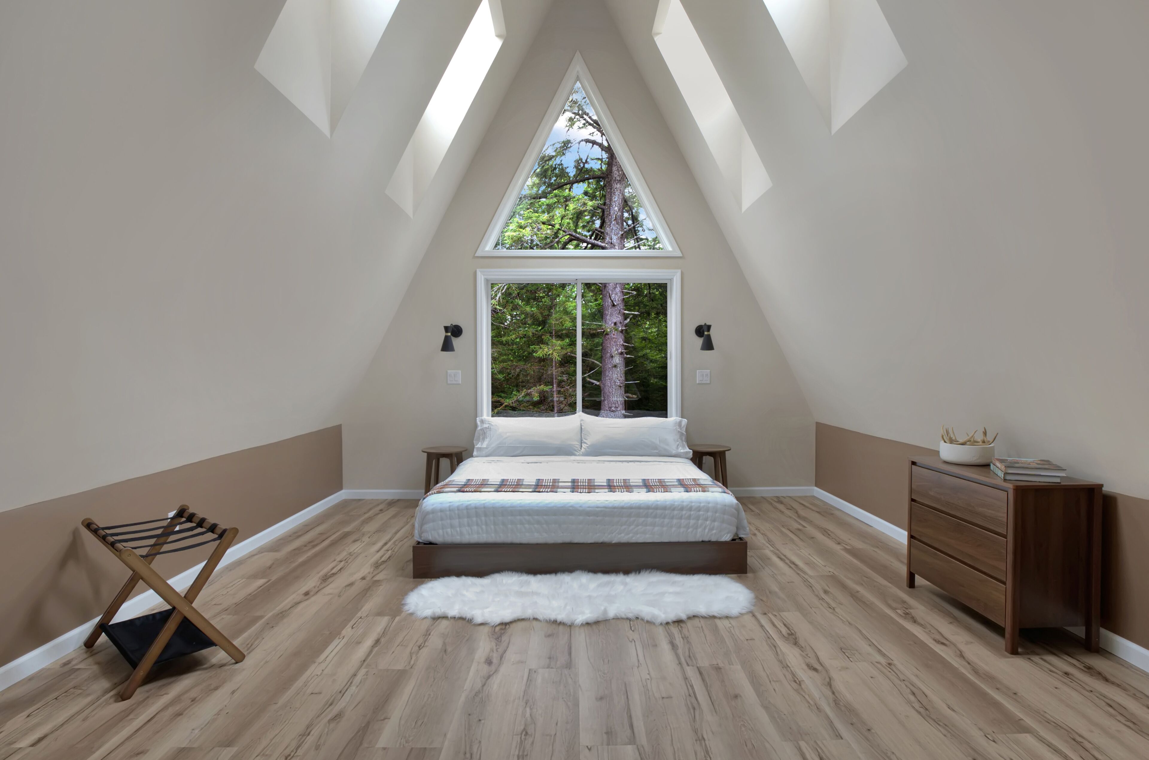 A bedroom with a sloped ceiling, a large window, a bed, a wooden dresser, and a fur rug.