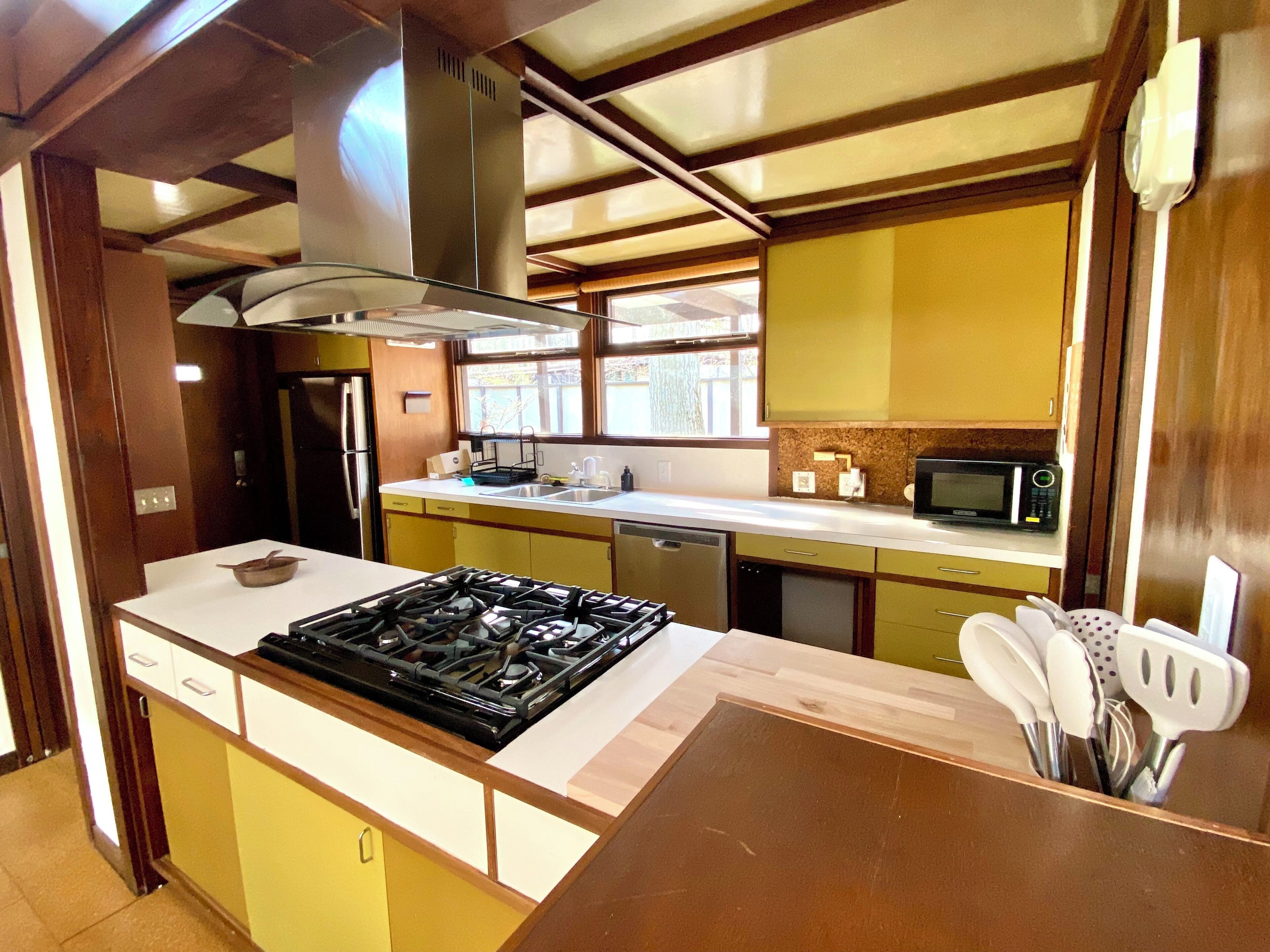 Una cocina funcional con estufa, microondas y muebles de cocina modernos.