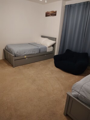 Een slaapkamer met een bed, een stoel en een schilderij aan de muur.