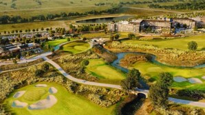 Un terrain de golf avec un hôtel en arrière-plan.