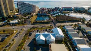 Ein Küstenhotelbereich mit mehreren Gebäuden, einem Parkplatz und Blick aufs Meer.