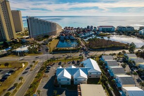 Ein Küstenhotelbereich mit mehreren Gebäuden, einem Parkplatz und Blick aufs Meer.