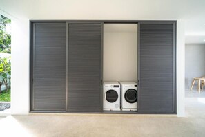 Ein modernes Interieur mit großem Schiebetürenschrank und Waschmaschine in der Mitte.
