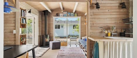 Interior acogedor de una cabaña con detalles de madera, un comedor, una cocina con fregadero y una chimenea.