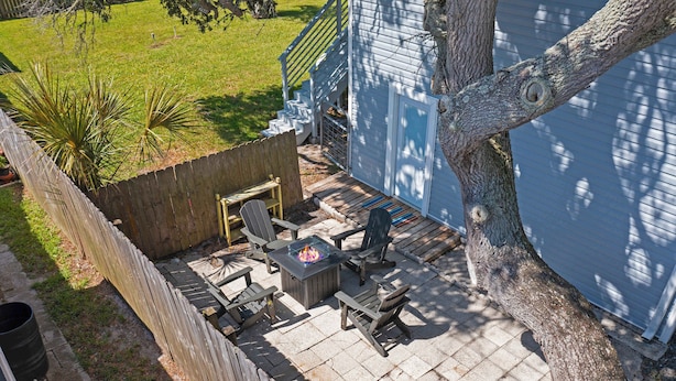 A patio with outdoor furniture, a fire pit, and a view of a house. - Walk to Surfside Beach Access, Golf Cart Add On (St. Augustine)