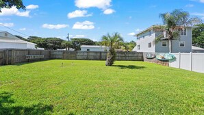 A backyard with a wooden deck, a fenced area, and a house. - Walk to Surfside Beach Access, Golf Cart Add On (St. Augustine)