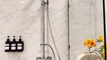 A modern bathroom with a shower, a toilet, and a sink.
