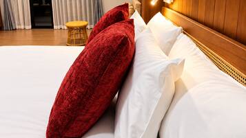 Habitación de hotel con una cama, una mesita de noche, una lámpara, un cuadro y vistas al exterior por la ventana.