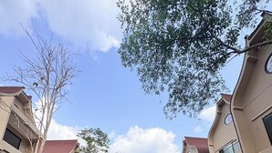 A residential complex with multiple-story buildings, a central water feature, and surrounding greenery. - T-Valley Maekampong  (Mae On)