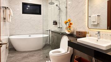 A modern bathroom with a bathtub, toilet, and sink.