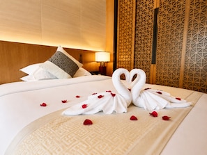 A hotel room with a neatly made bed, a decorative pillow, a wall with geometric patterns, and a bedside lamp. - The Floral Dreamscape Retreat -Yulong Romance Park Branch-Tickets Reservation & Day Tour Arrangement (Guilin)