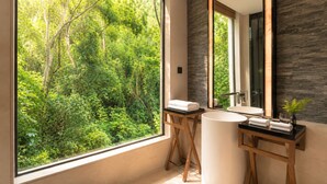 Un baño con un ventanal grande, un lavabo y un espejo.