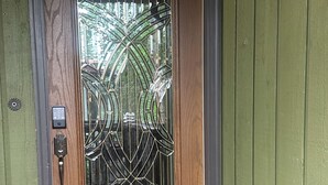 A wooden door with a metal gate, a keypad lock, and a welcome mat. - 4BR/4BA Lakefront Lodge- mountain views, wildlife, canoeing- 9 min to airport (Anchorage)