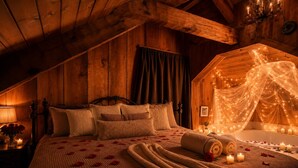 A cozy, dimly lit wooden room with a bed, a small table with a lamp, and a decorative canopy over a bathtub. - Romantic Private Forrest Hideaway + Heart Shaped Tub + Hot Tub! (Sevierville)