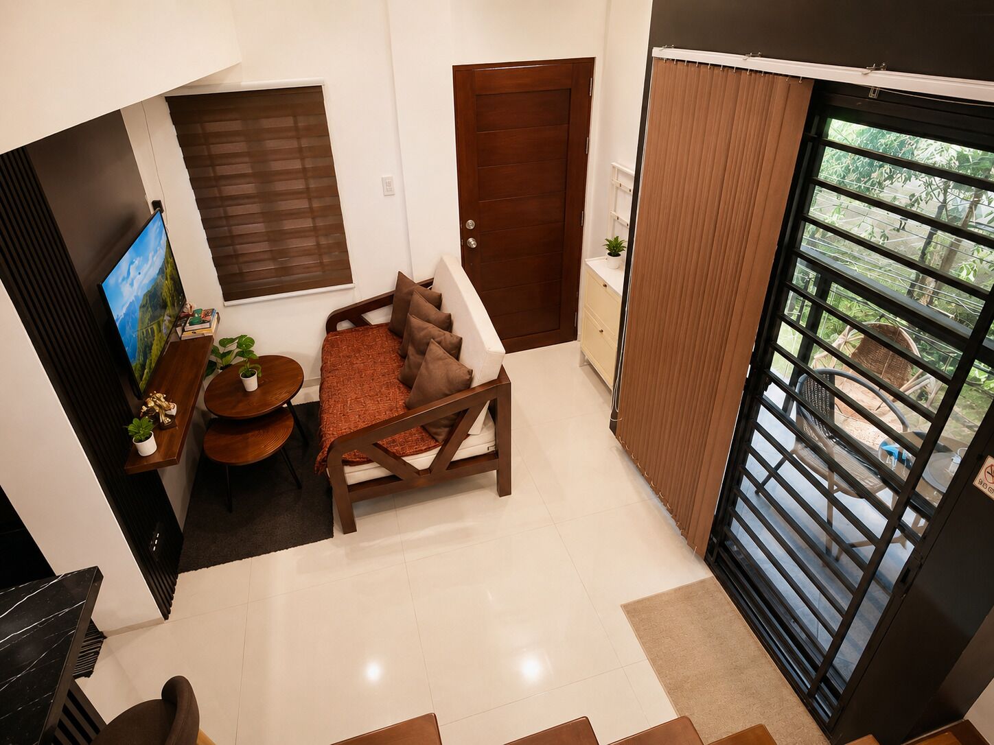 A modern living room with a sofa, TV, and dining area.