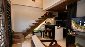 Et moderne interiør med trappe, et køkken og en opholdsstue med tv.