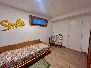 A bedroom with a bed, a desk, a chair, a window, and a door. - Villa Blu di Norsi: 100 steps to sea and peace (Capoliveri)