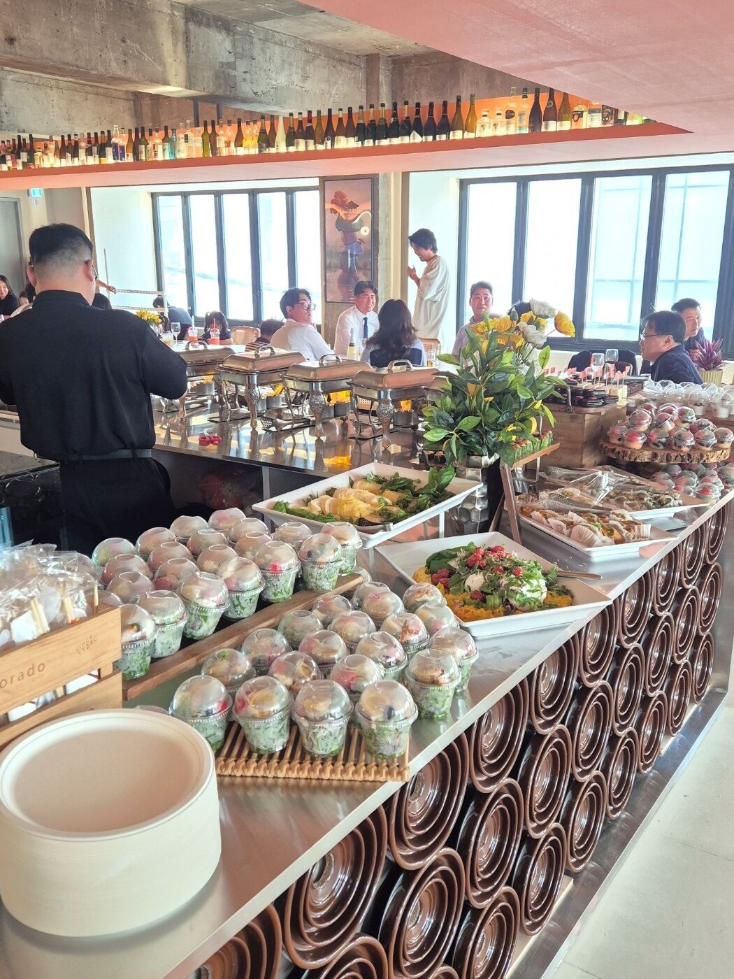 A buffet setup with various food items and a bartender serving drinks.