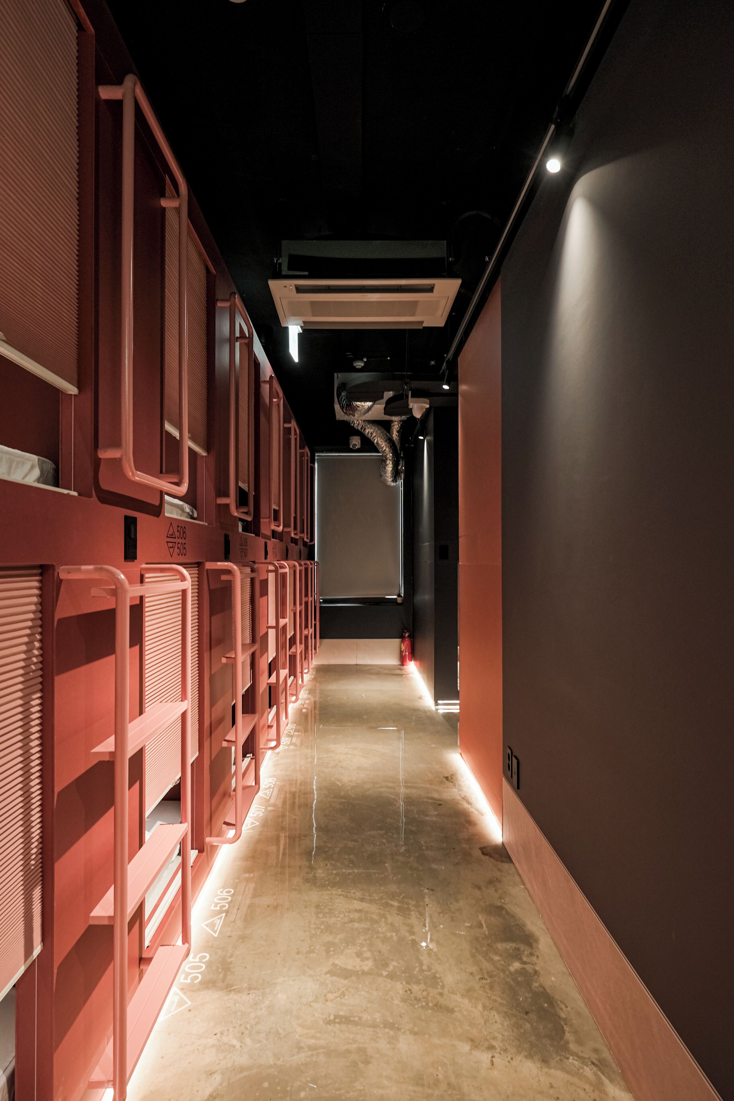 A corridor with bunk beds and a fire extinguisher.