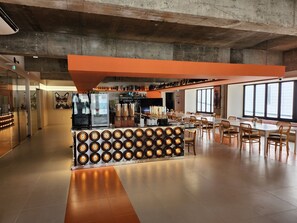 A modern bar area with a central island, seating, and a large window providing natural light. - Jh blossom capsule & cabin hotel (Busan)