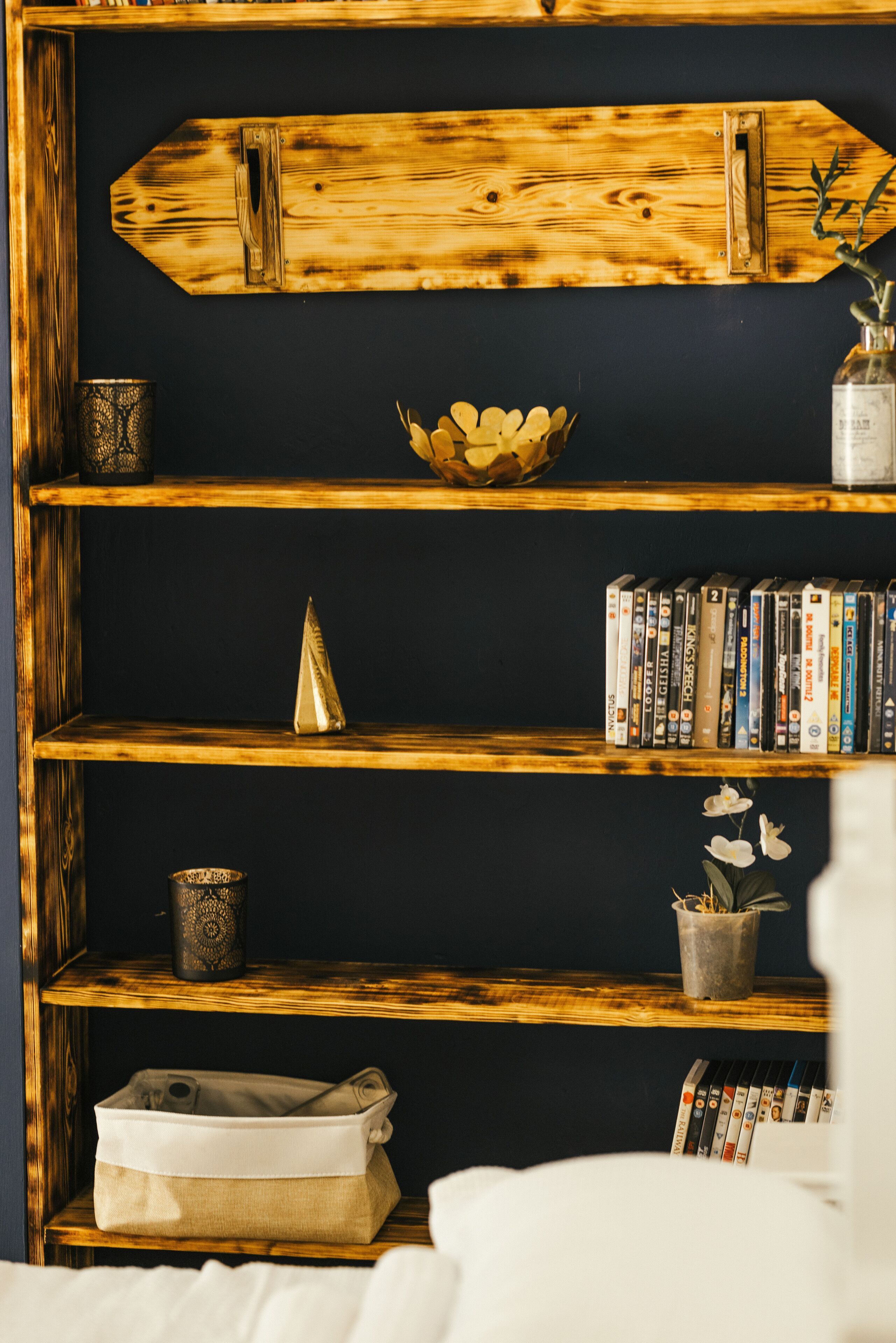 A bookshelf with a variety of items including books, a decorative bowl, and a small plant.